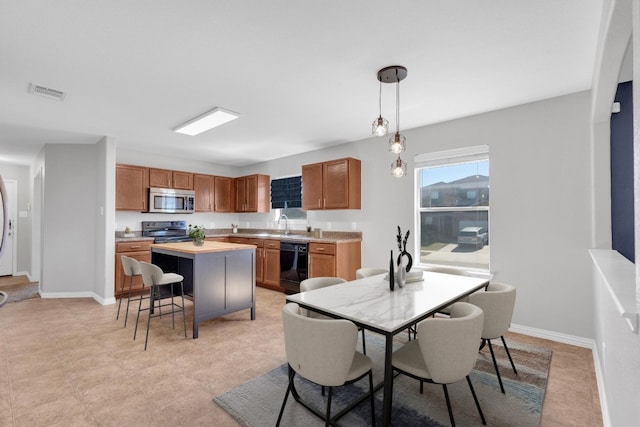 kitchen featuring stainless steel microwave, baseboards, dishwasher, and visible vents