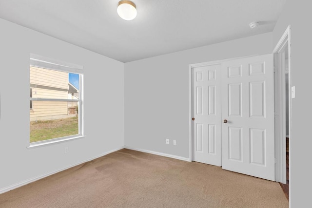 unfurnished bedroom featuring a closet, baseboards, and carpet