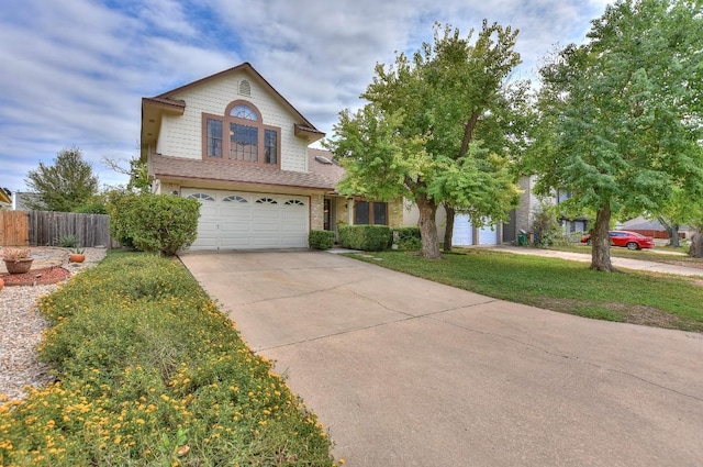 traditional home with concrete driveway, fence, a garage, and a front yard