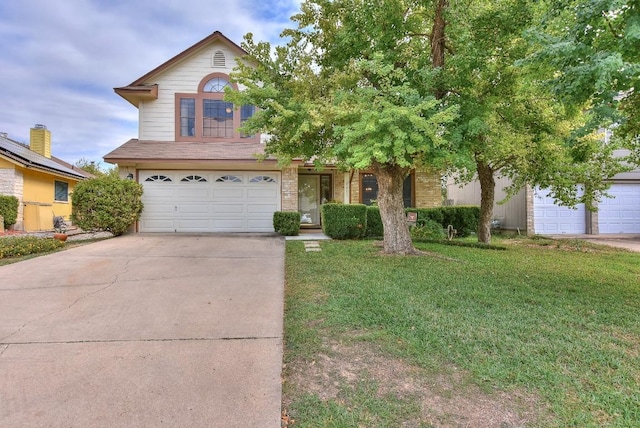 traditional-style home with brick siding, a garage, driveway, and a front lawn