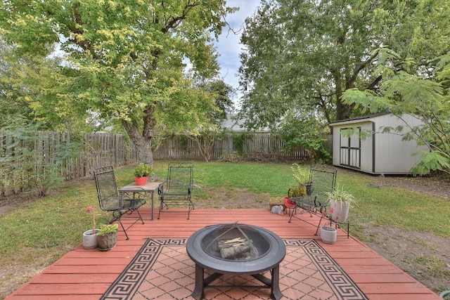 view of patio / terrace featuring a fenced backyard, a storage unit, a wooden deck, and an outdoor structure