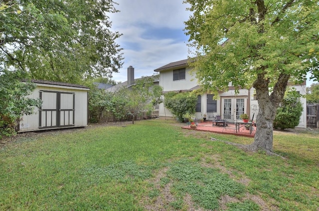 view of yard with an outdoor structure, a storage unit, french doors, and fence