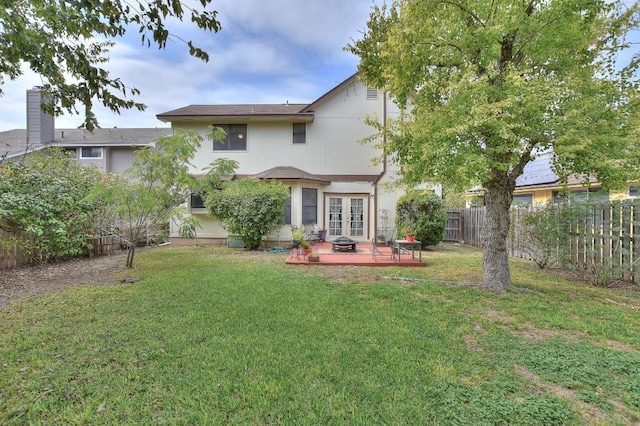 rear view of property with a patio area, a lawn, french doors, and a fenced backyard