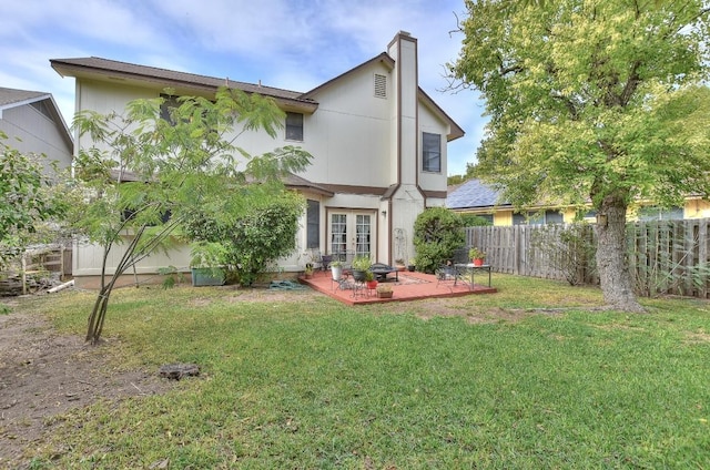 back of property featuring a lawn, fence, french doors, a chimney, and a patio area