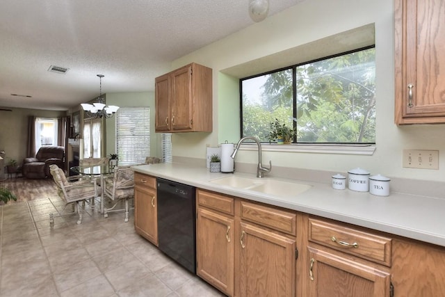 kitchen featuring a sink, light countertops, a textured ceiling, dishwasher, and open floor plan