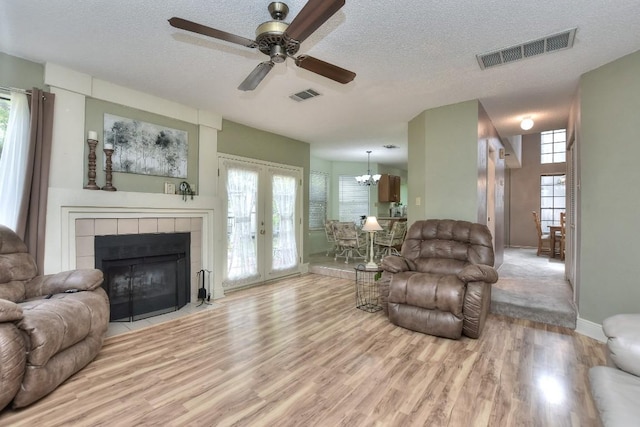 living room with wood finished floors, visible vents, and a textured ceiling