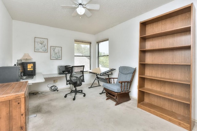 office area featuring ceiling fan, carpet flooring, and a textured ceiling