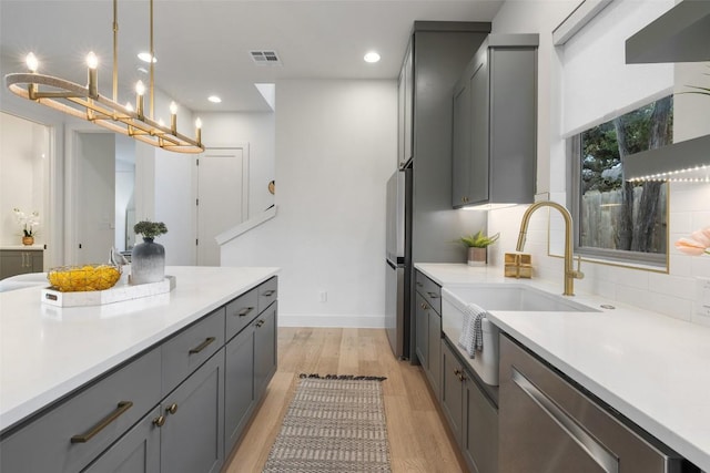 kitchen featuring light countertops, gray cabinets, visible vents, and light wood finished floors