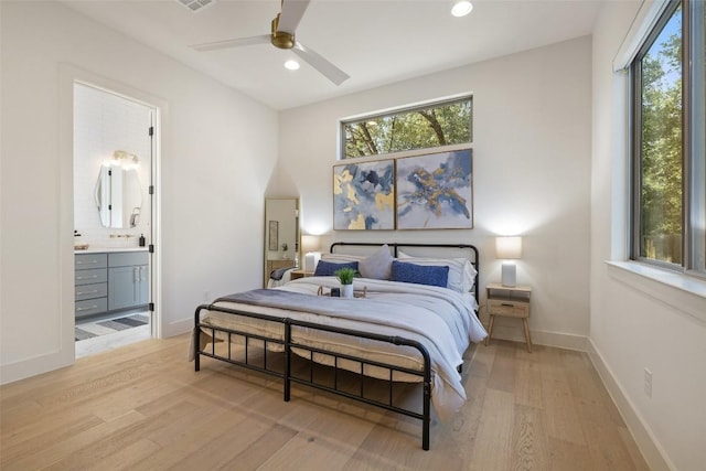 bedroom featuring light wood finished floors, visible vents, connected bathroom, baseboards, and recessed lighting