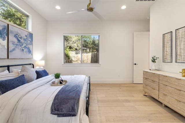 bedroom featuring recessed lighting, baseboards, multiple windows, and light wood-style floors