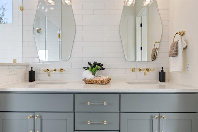 bathroom featuring double vanity, tasteful backsplash, and a sink