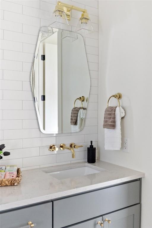 bathroom with tasteful backsplash and vanity