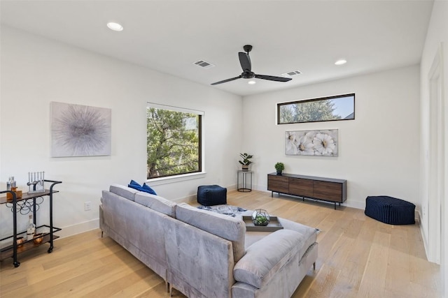 living area with visible vents, plenty of natural light, and wood finished floors