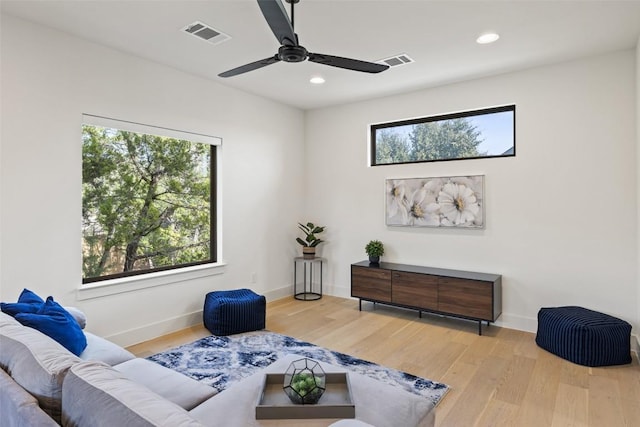 living area featuring wood finished floors, visible vents, and baseboards