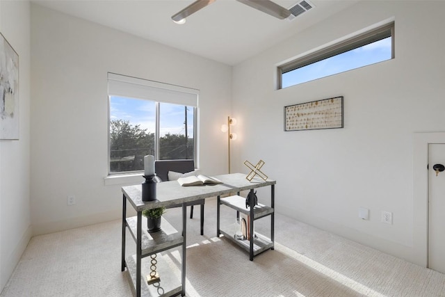 office area featuring plenty of natural light, visible vents, and light carpet