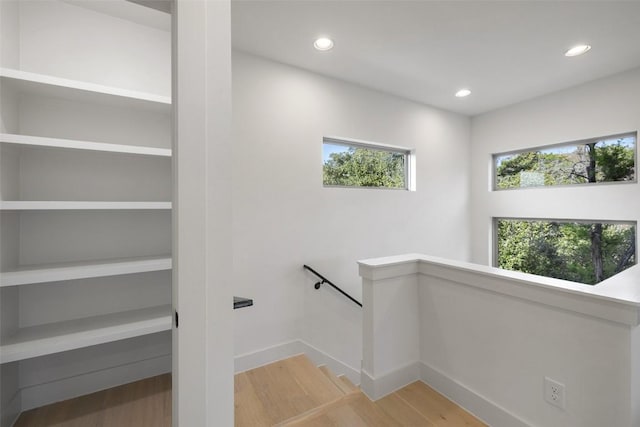 stairway with recessed lighting, baseboards, and wood finished floors