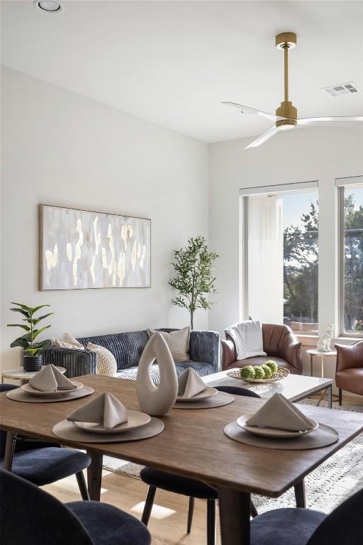 interior space featuring wood finished floors, a ceiling fan, visible vents, and breakfast area