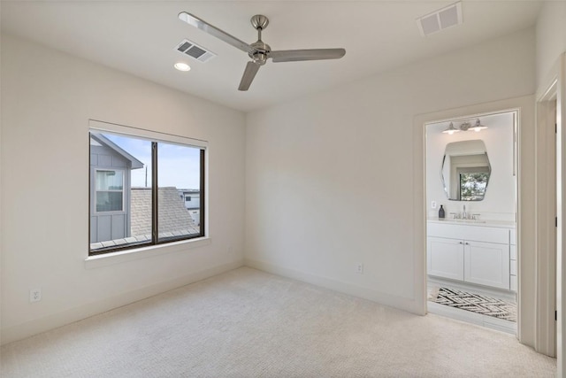 unfurnished bedroom with visible vents, a sink, baseboards, and carpet floors