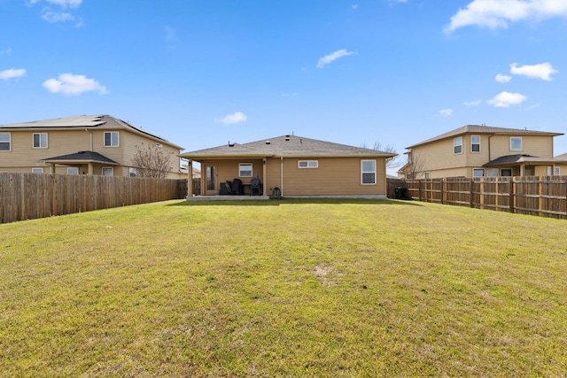 back of property with a fenced backyard, a patio area, and a yard