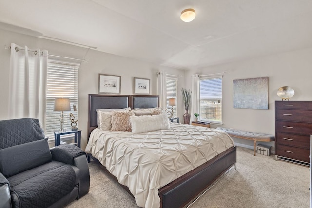 bedroom with multiple windows and light colored carpet