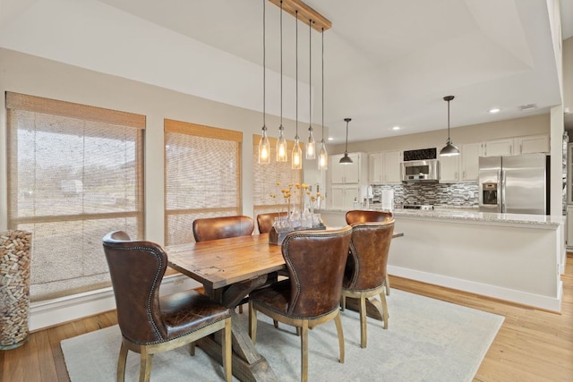 dining area featuring recessed lighting, baseboards, and light wood finished floors