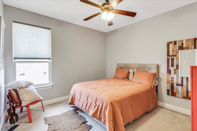 bedroom featuring baseboards, light colored carpet, and a ceiling fan