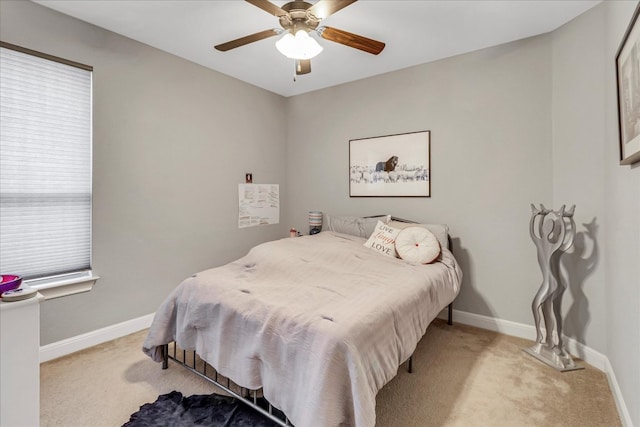carpeted bedroom with ceiling fan and baseboards
