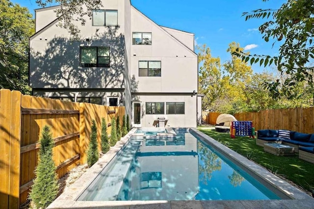 rear view of property with an outdoor living space, a fenced backyard, and stucco siding