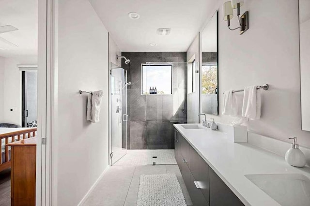 full bath with double vanity, tile patterned flooring, a shower stall, and a sink