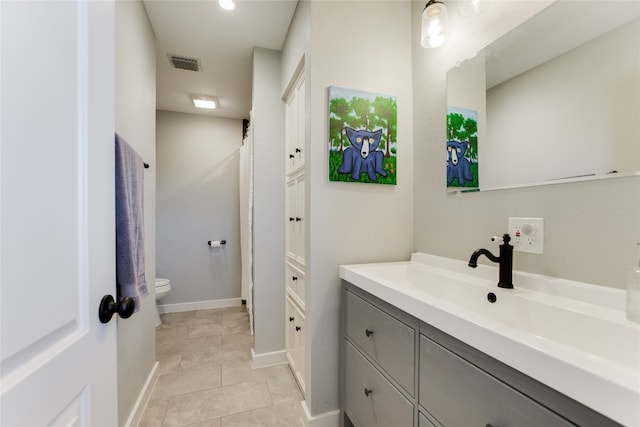 bathroom with tile patterned floors, visible vents, toilet, baseboards, and vanity