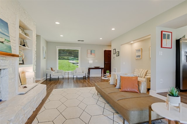 living room with visible vents, recessed lighting, a fireplace, and light wood-style floors