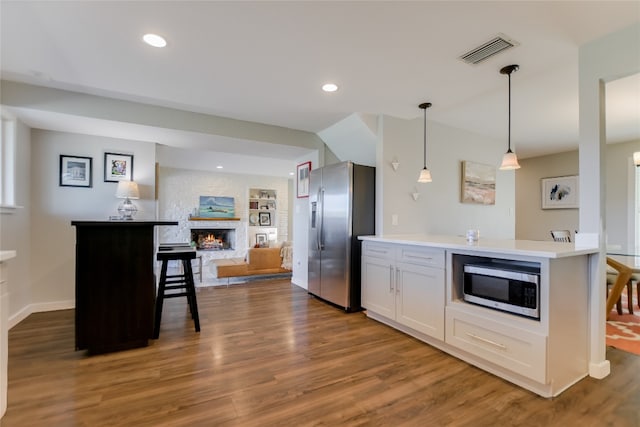 8603 Appalachian Dr, Austin, TX 78759 - kitchen featuring appliances with stainless steel finishes, a fireplace, dark wood-type flooring, recessed lighting, and light countertops