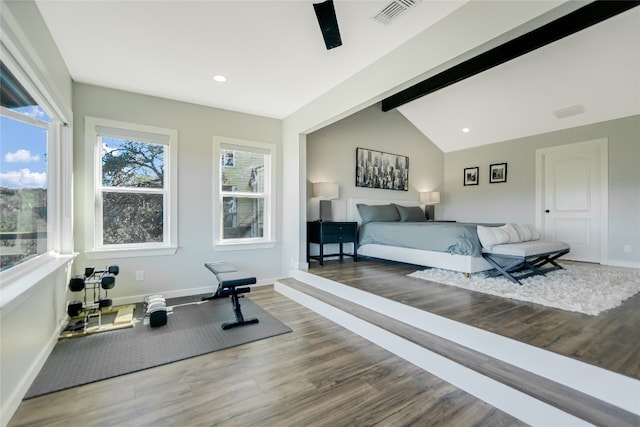 bedroom with visible vents, lofted ceiling with beams, baseboards, and wood finished floors