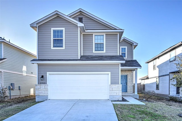 view of front of property featuring concrete driveway, an attached garage, and stone siding