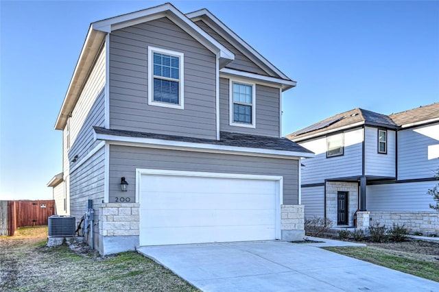 view of front facade with fence, central AC, concrete driveway, stone siding, and a garage