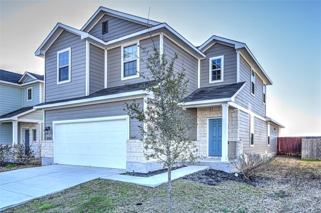 view of front facade with stone siding, concrete driveway, a garage, and fence