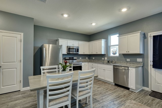 220 Wonderful Life Way, Jarrell, TX 76537 - kitchen with stainless steel appliances, white cabinets, wood finished floors, and recessed lighting