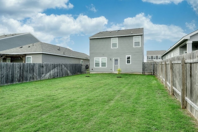 back of property featuring a yard and a fenced backyard