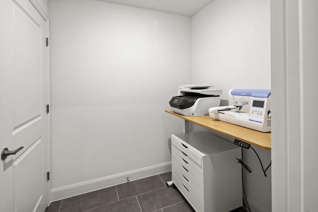 office space with baseboards and dark tile patterned floors