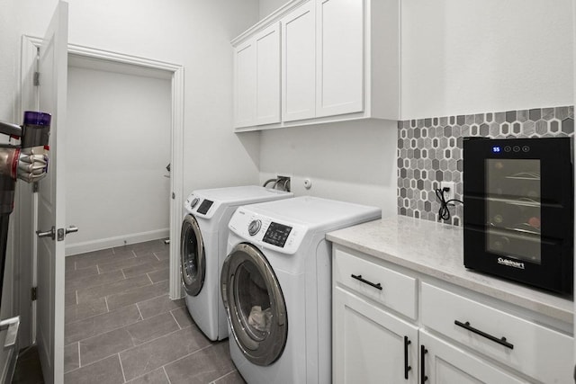 clothes washing area featuring baseboards, cabinet space, and washing machine and clothes dryer