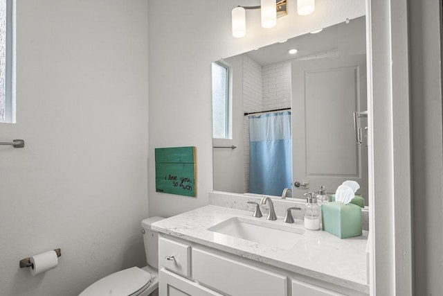 bathroom featuring toilet, vanity, and a shower with curtain