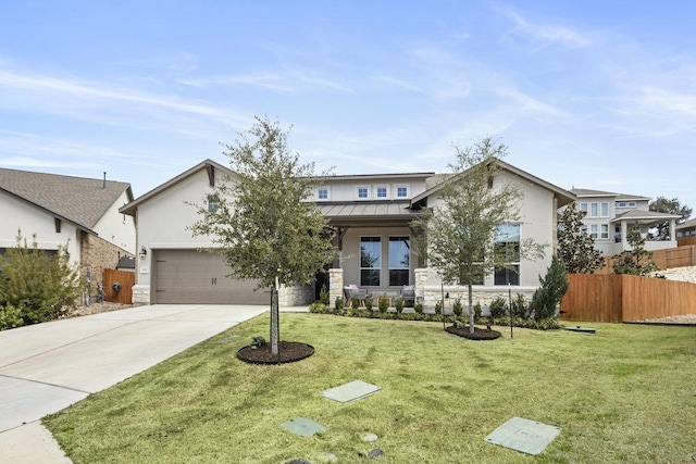 view of front facade with fence, driveway, a standing seam roof, a front lawn, and metal roof