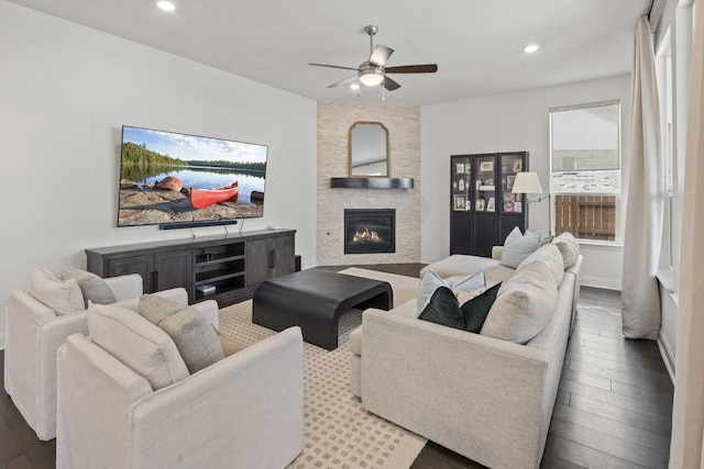 living room with a stone fireplace, recessed lighting, ceiling fan, and wood finished floors