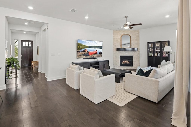 living area featuring visible vents, recessed lighting, a stone fireplace, baseboards, and dark wood-style flooring