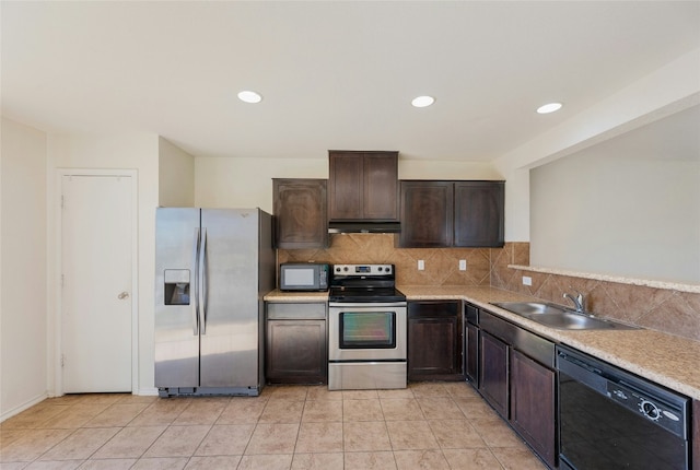 kitchen with black appliances, a sink, under cabinet range hood, dark brown cabinetry, and decorative backsplash