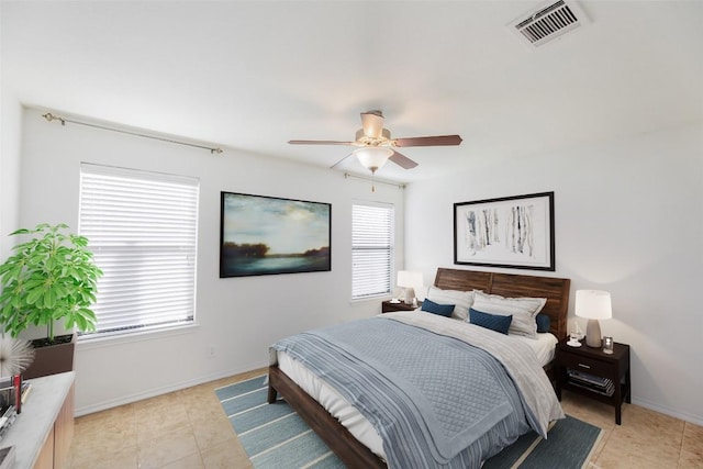 bedroom featuring light tile patterned floors, visible vents, baseboards, and a ceiling fan