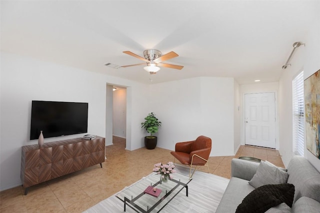 living area featuring light tile patterned floors, visible vents, and a ceiling fan