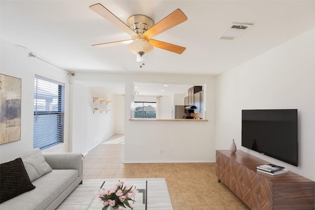 living area with light tile patterned flooring, a healthy amount of sunlight, visible vents, and ceiling fan