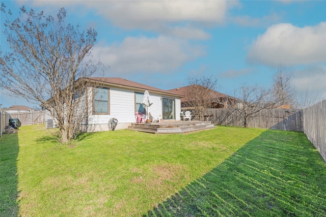 back of house with a fenced backyard, a deck, and a yard