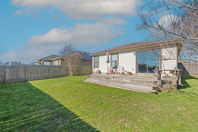 rear view of property with a deck, a yard, and a fenced backyard